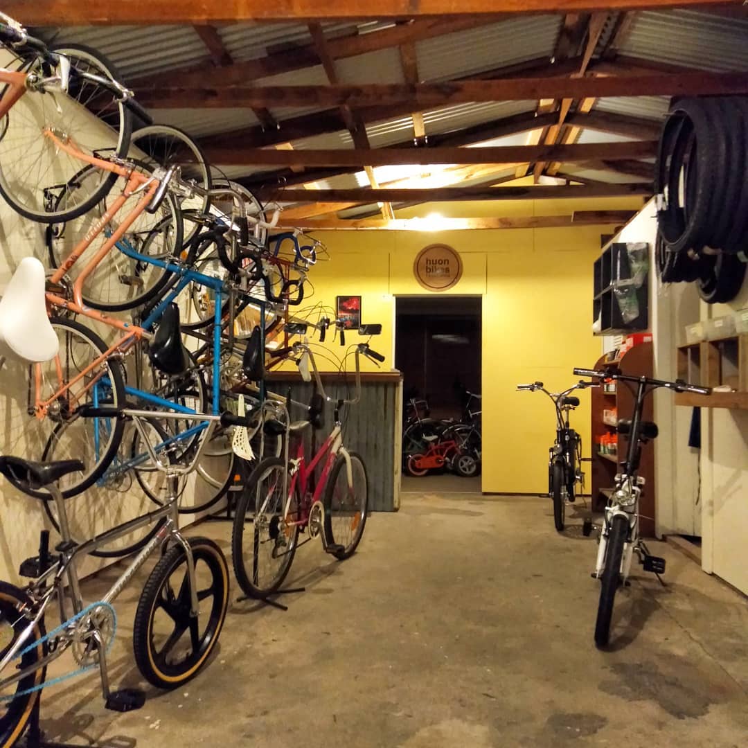 Inside the Huon Bikes workshop: vintage bicycles hung along the wall under timber rafters