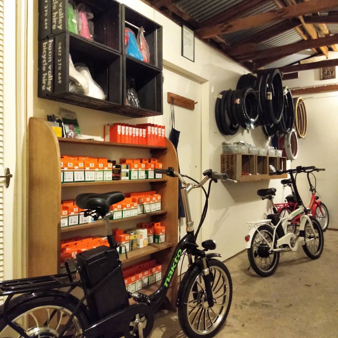 Parts shelving stacked with tube boxes, with electric bikes parked alongside