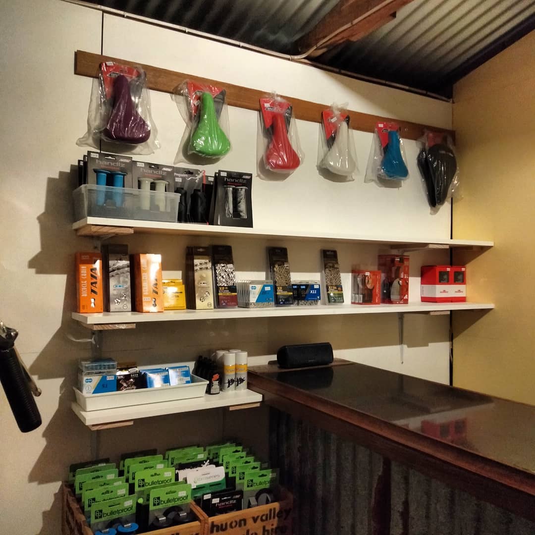 The accessories wall at Huon Bikes: coloured saddles, chains, tubes and lubricants